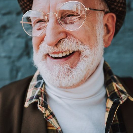 Stylish man smiling on a blue-brick background