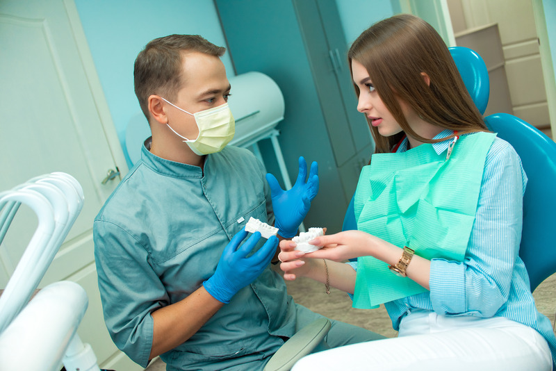Patient talking with dentist about dental implants